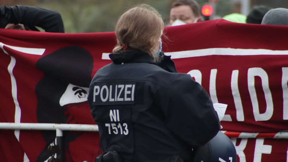 a police officer standing in front of a red banner