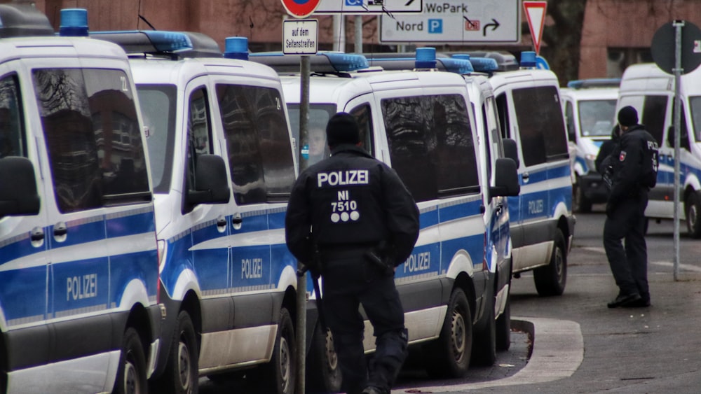 a police officer standing in front of a line of police vans