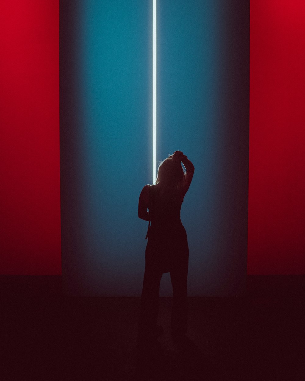 a person standing in front of a red and blue wall