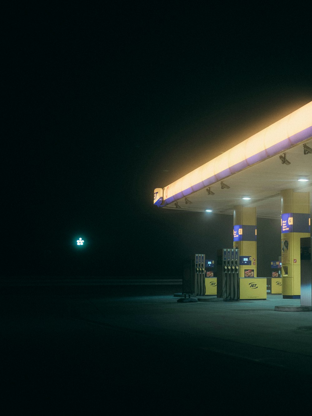 eine Tankstelle in der Nacht mit eingeschaltetem Licht