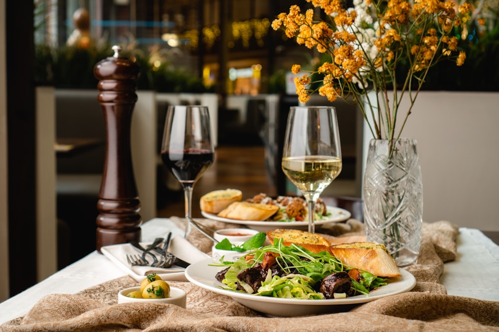 a table topped with plates of food and glasses of wine