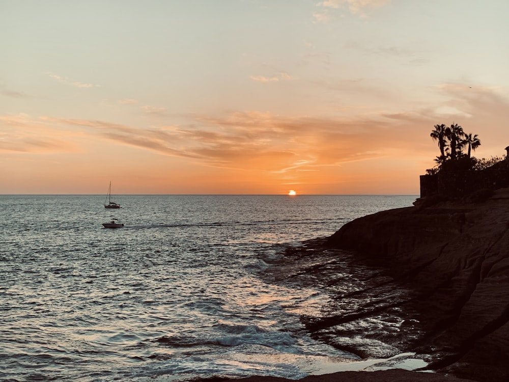 a boat is out on the water at sunset