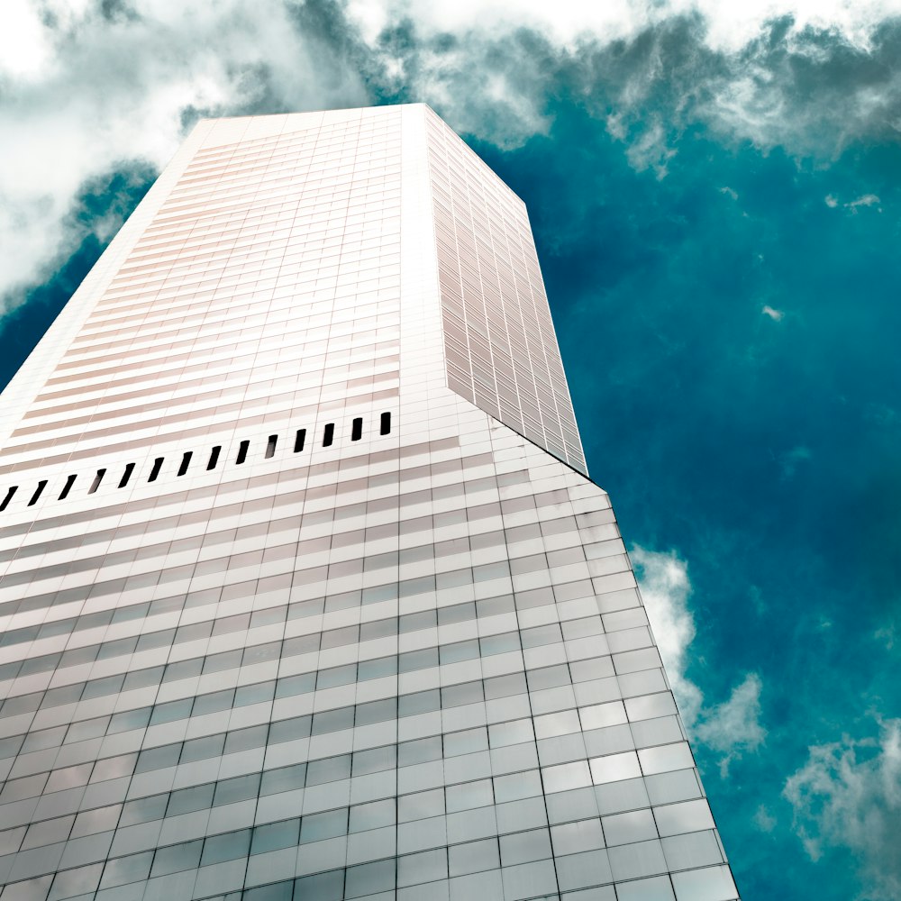 a very tall building sitting under a cloudy blue sky