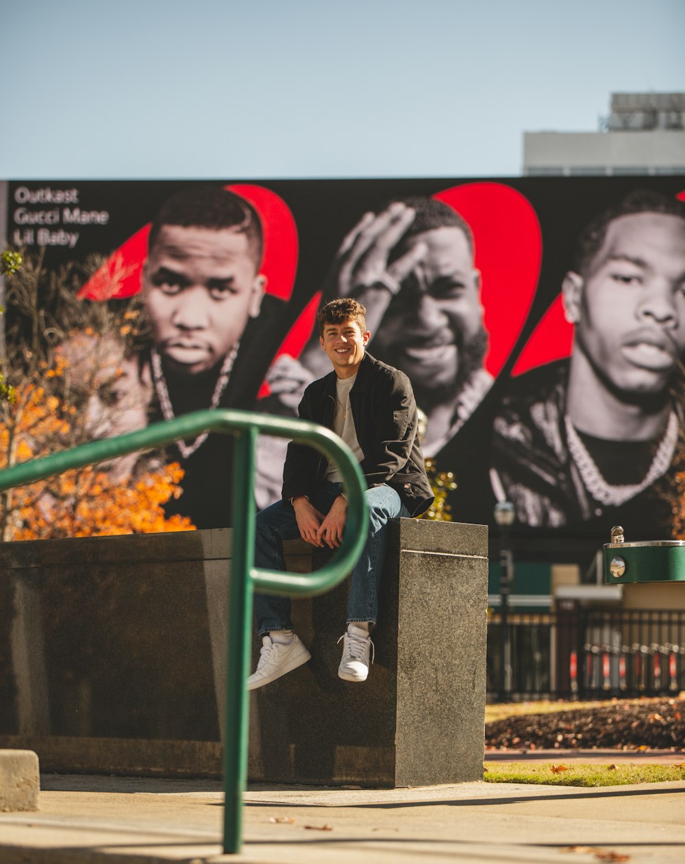 a man sitting on a cement block in front of a mural