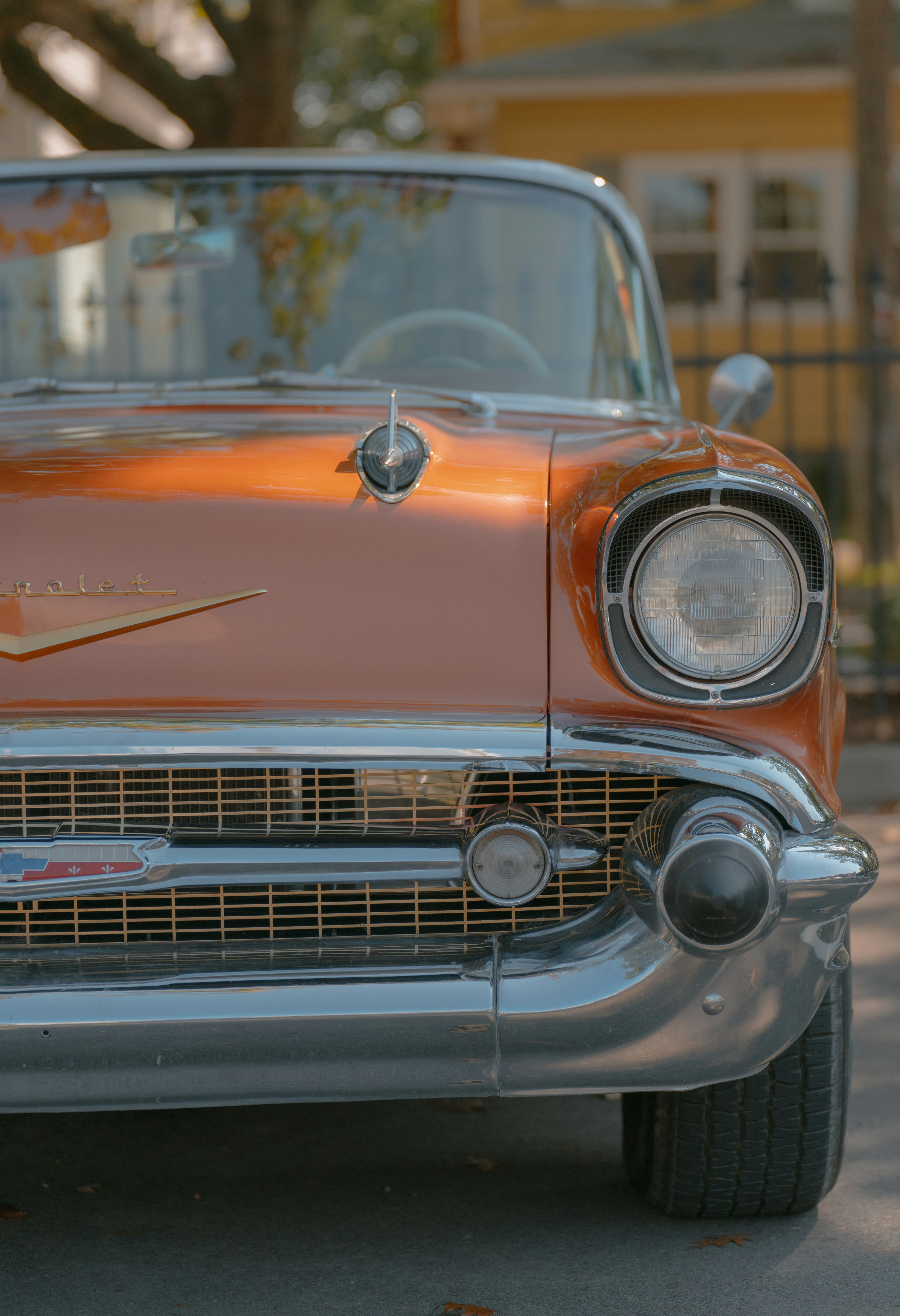 the front end of a classic car parked on the street