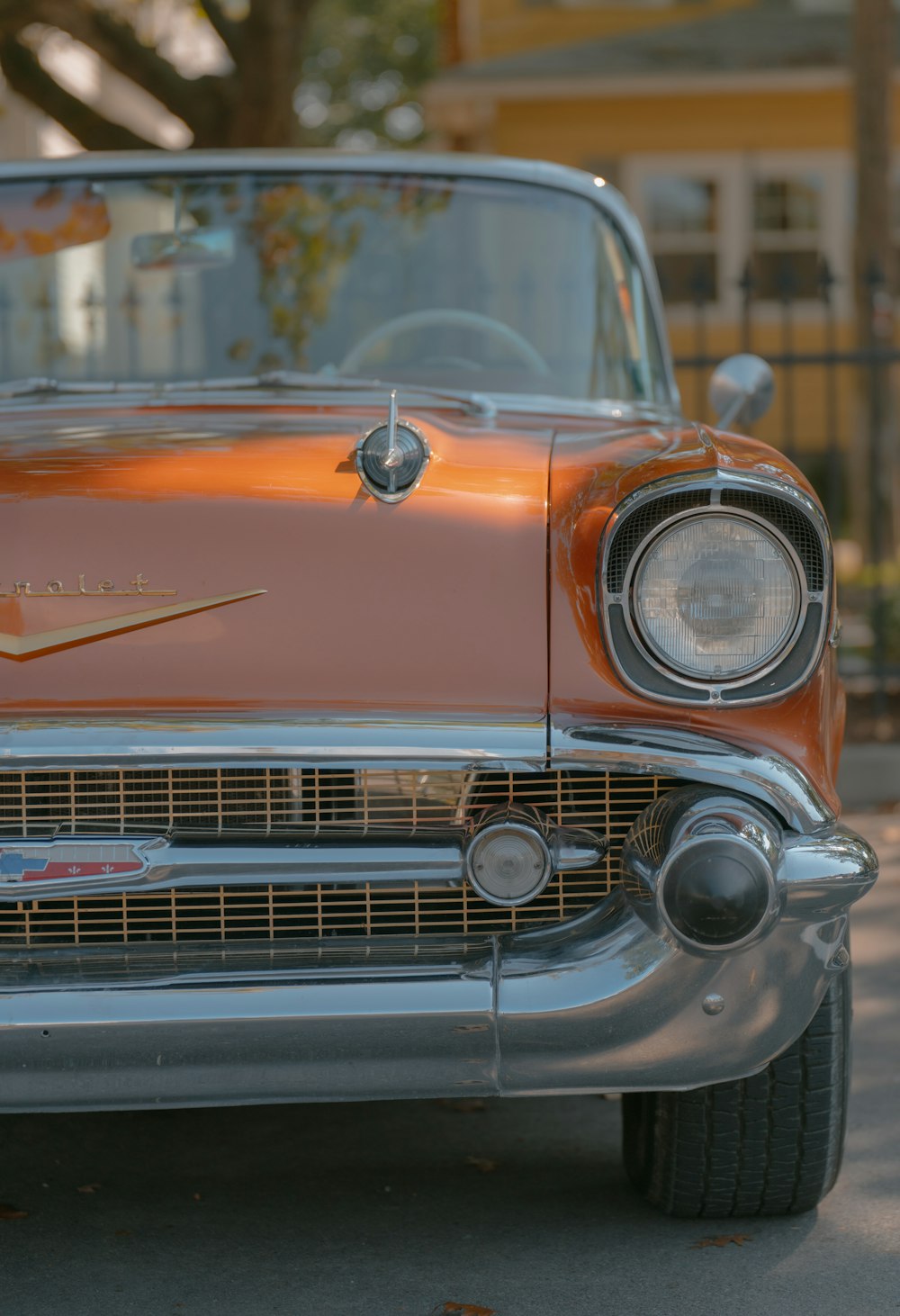 the front end of a classic car parked on the street