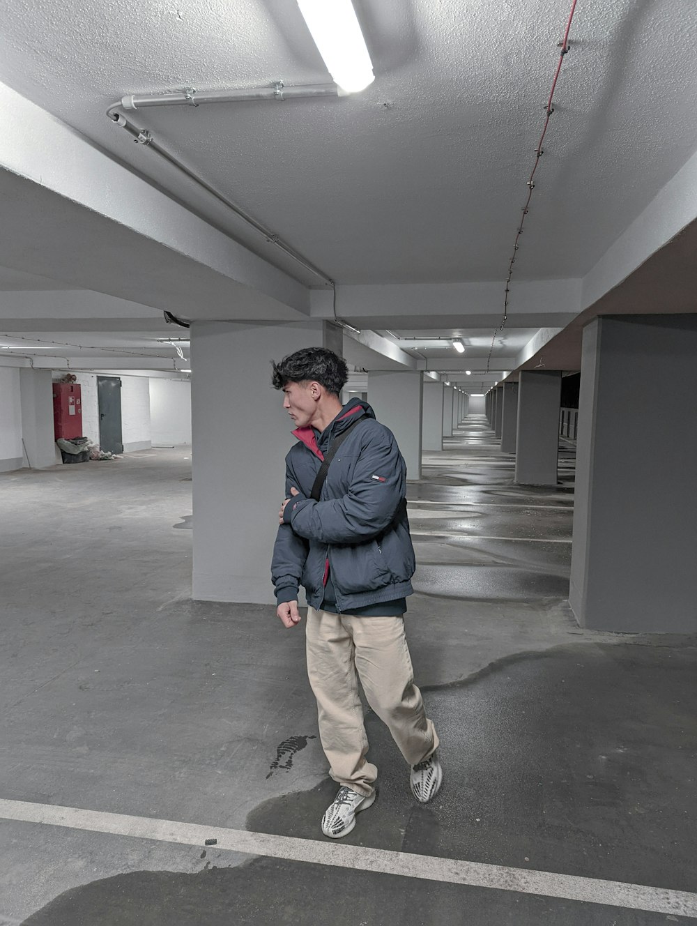 a man is standing in a parking garage