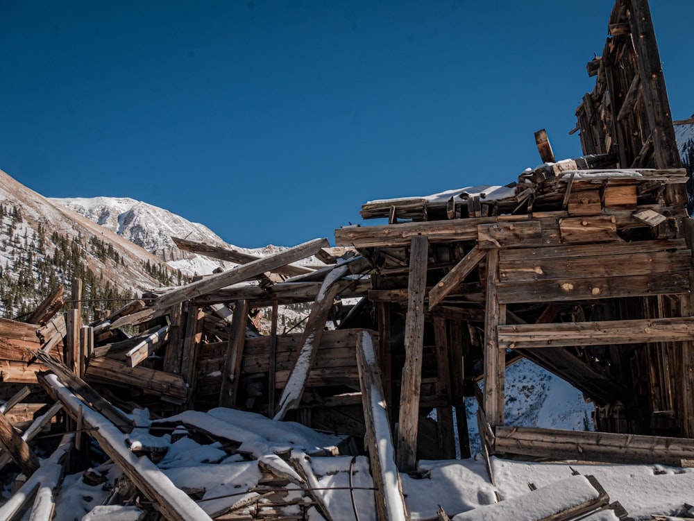 a pile of wood sitting on top of a snow covered ground