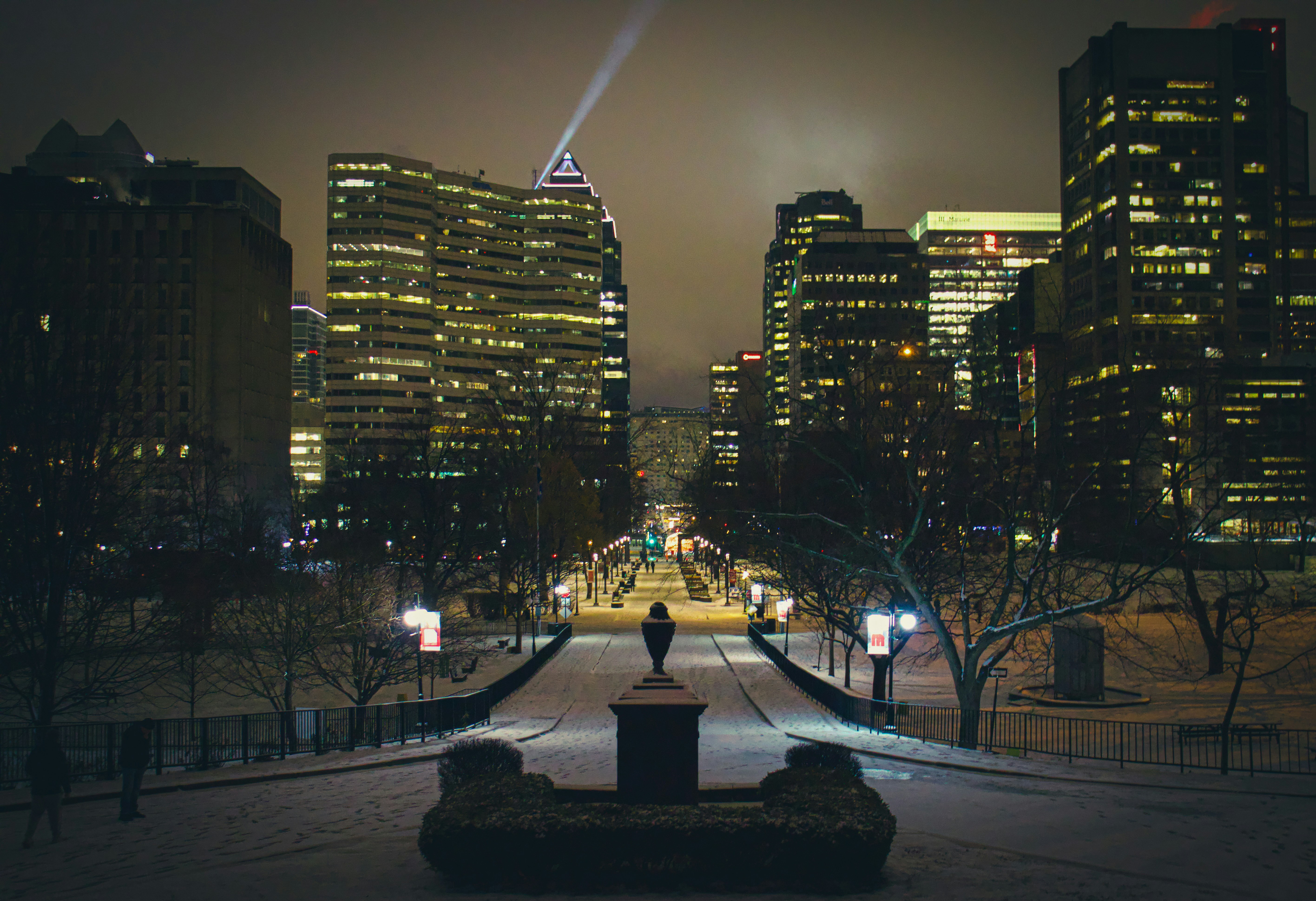 a person standing on a bench in the middle of a city at night