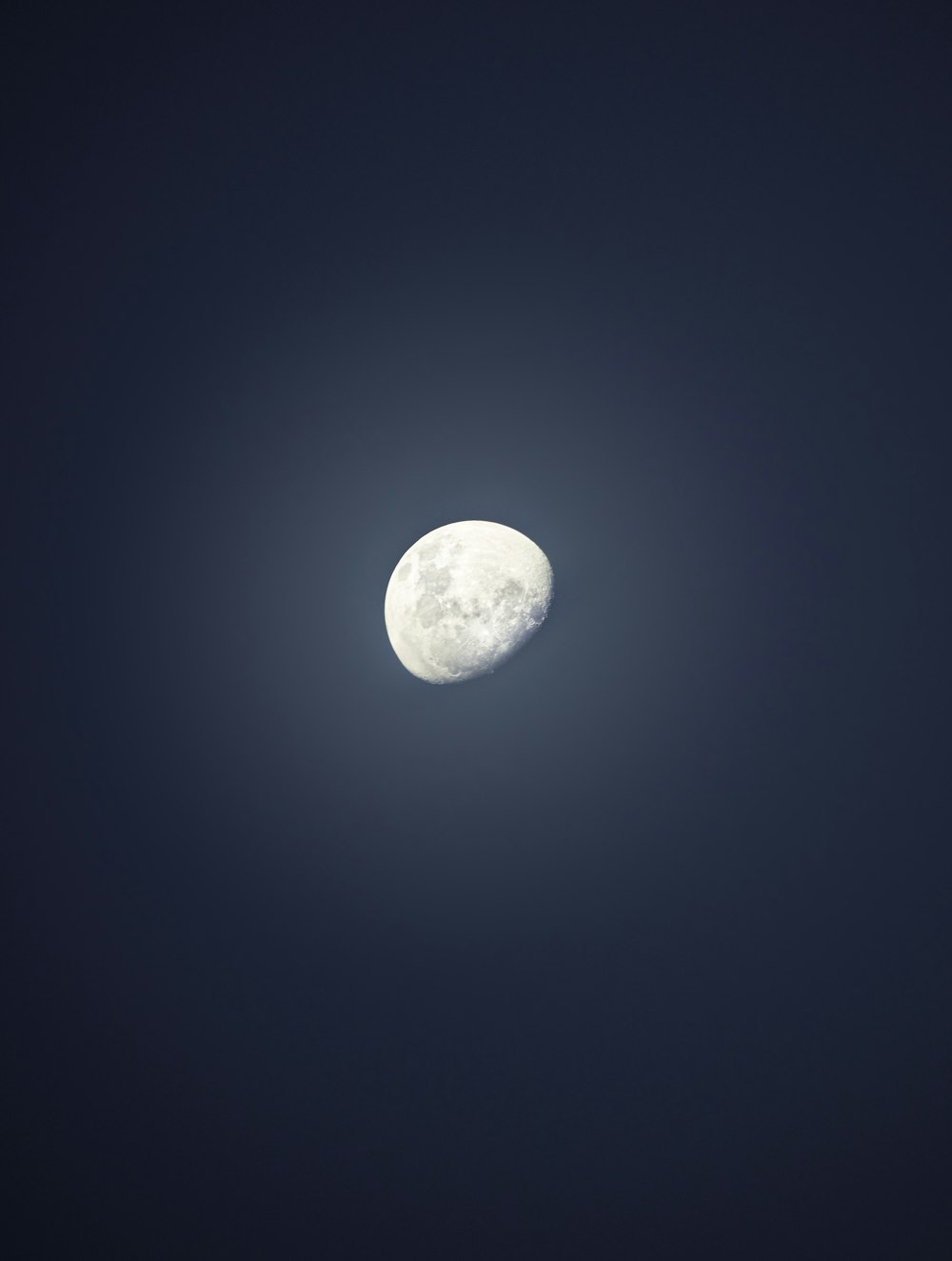 a full moon is seen in the dark sky