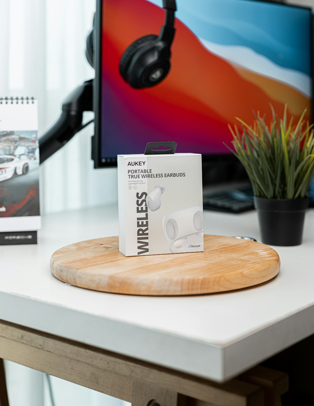 a desk with a computer monitor and headphones on it