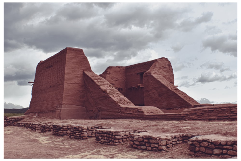 a large brick structure sitting on top of a dirt field