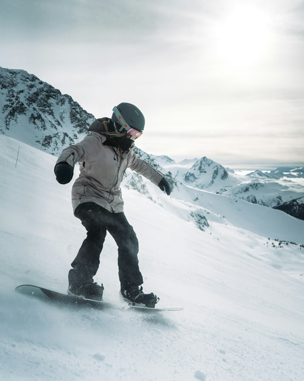 a person riding a snowboard down a snow covered slope