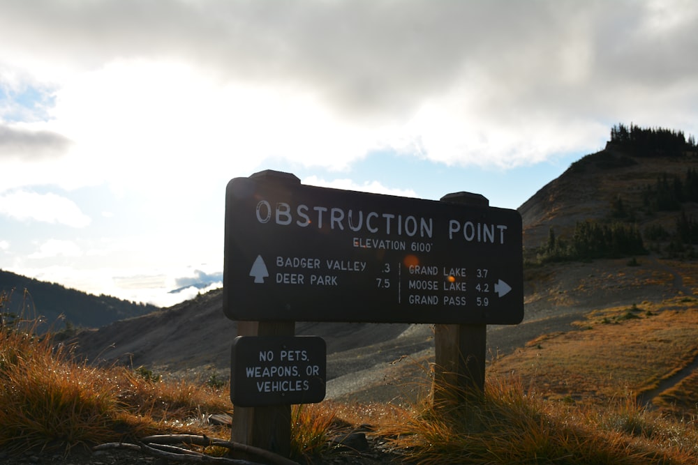 a sign on the side of a mountain pointing to an obstruction point