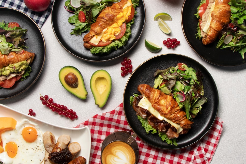 a table topped with black plates filled with food