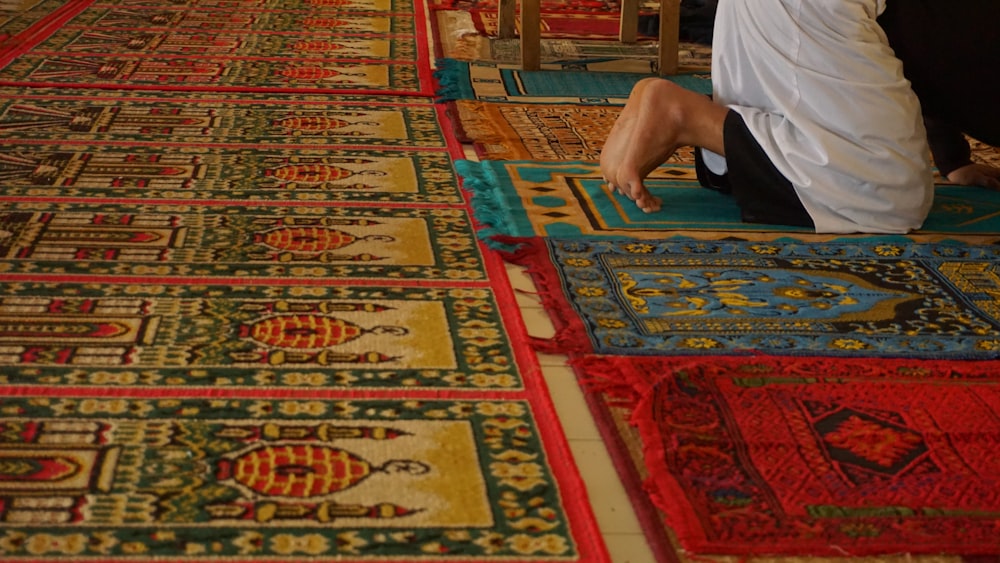 a man sitting on a rug in a room