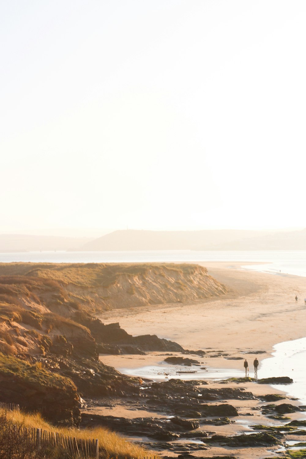 a group of people standing on top of a sandy beach