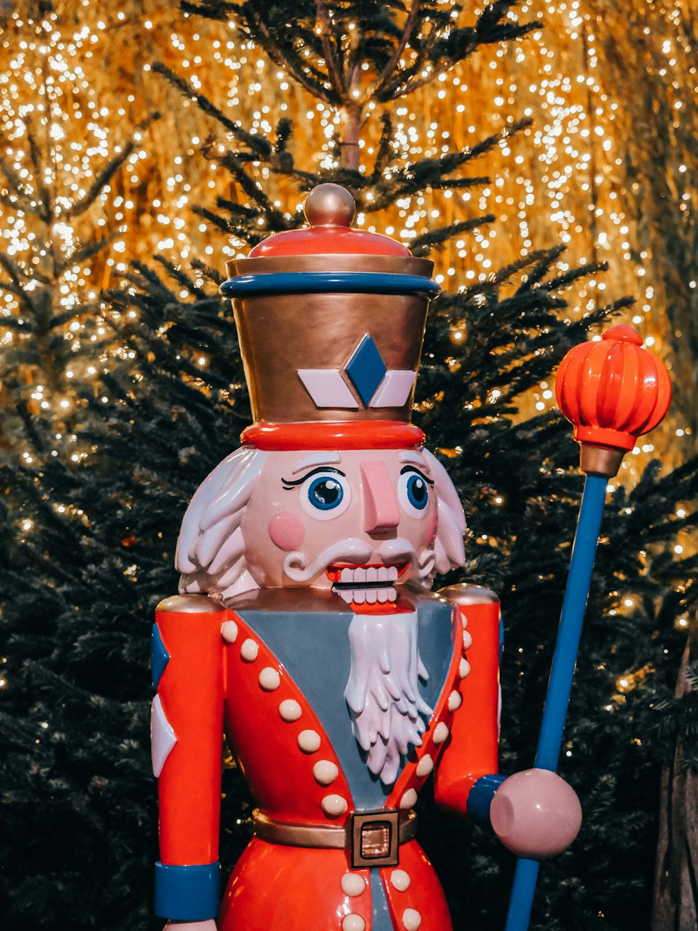 a nutcracker is standing in front of a christmas tree