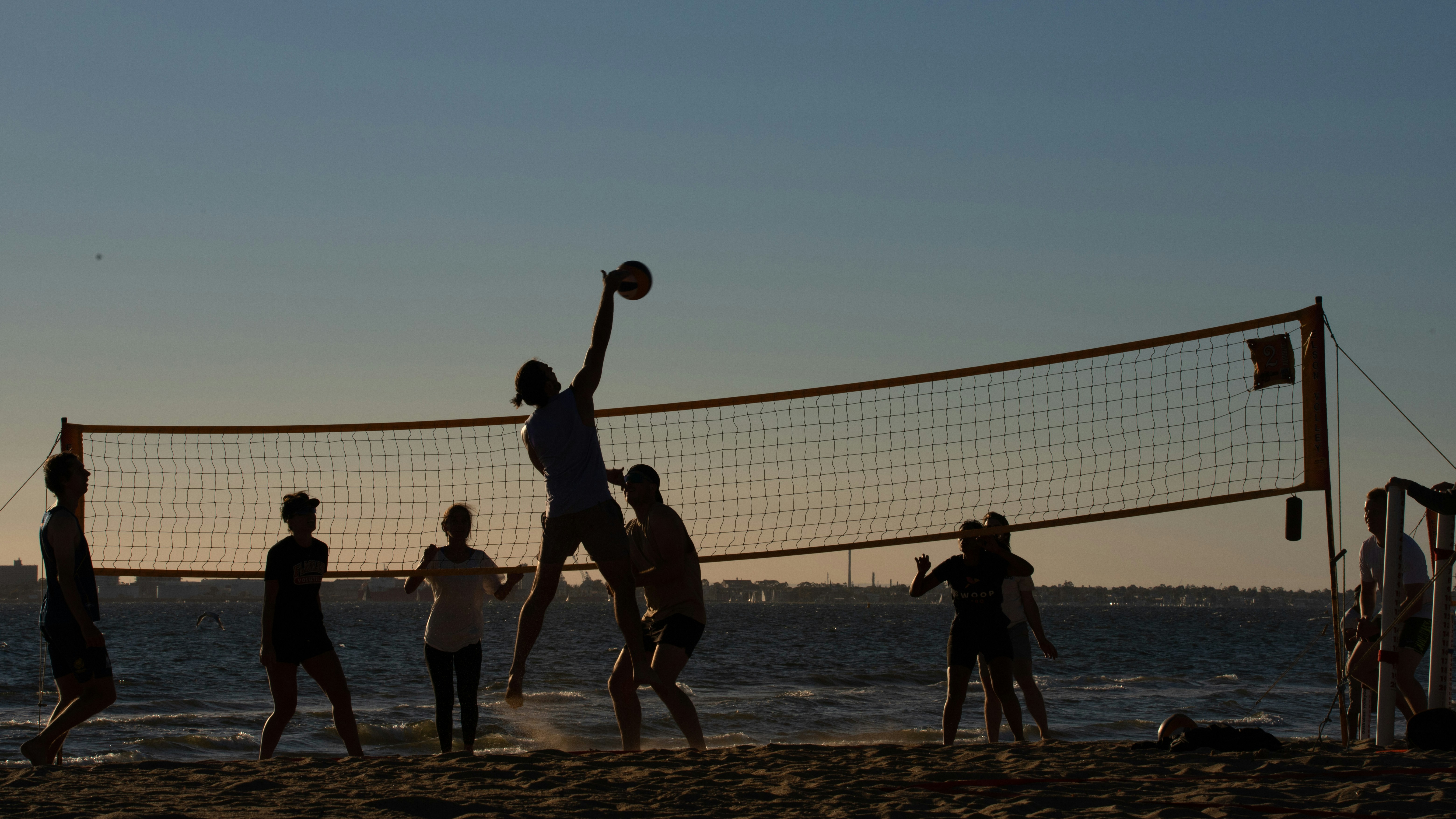 a group of people playing volleyball on the beach