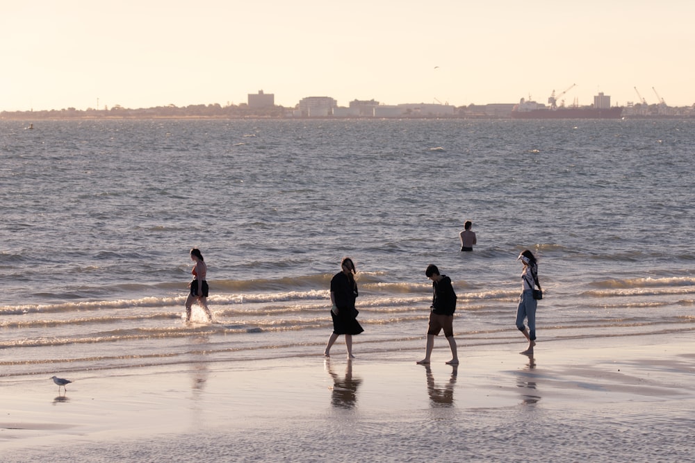 Eine Gruppe von Menschen, die an einem Strand am Meer entlang spazieren gehen