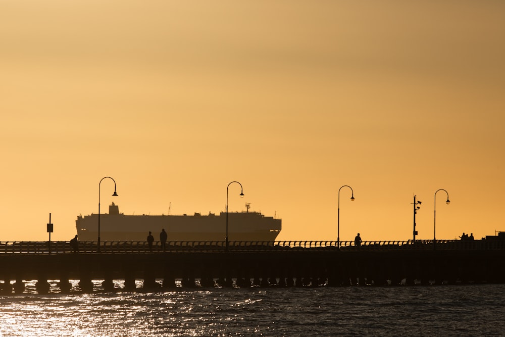 a large boat in the water near a pier