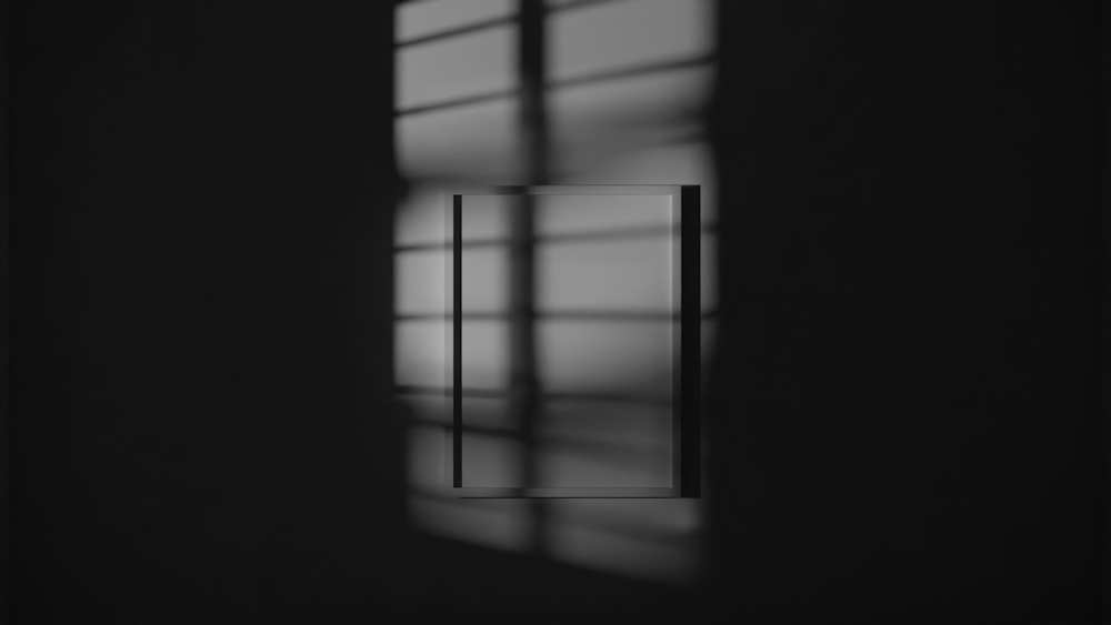 a black and white photo of a window in a dark room