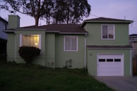 a green house with a tree in the background
