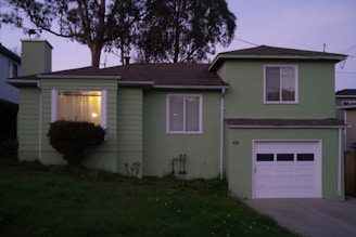 a green house with a tree in the background