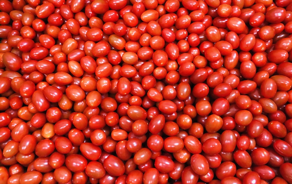 a large pile of red tomatoes sitting on top of a table