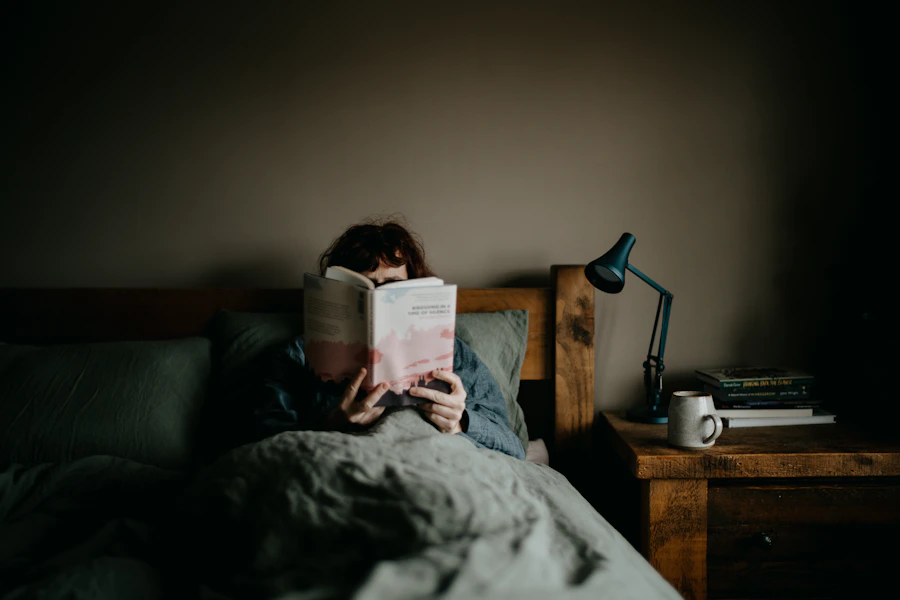 Person resting and reading in bed in soft morning light