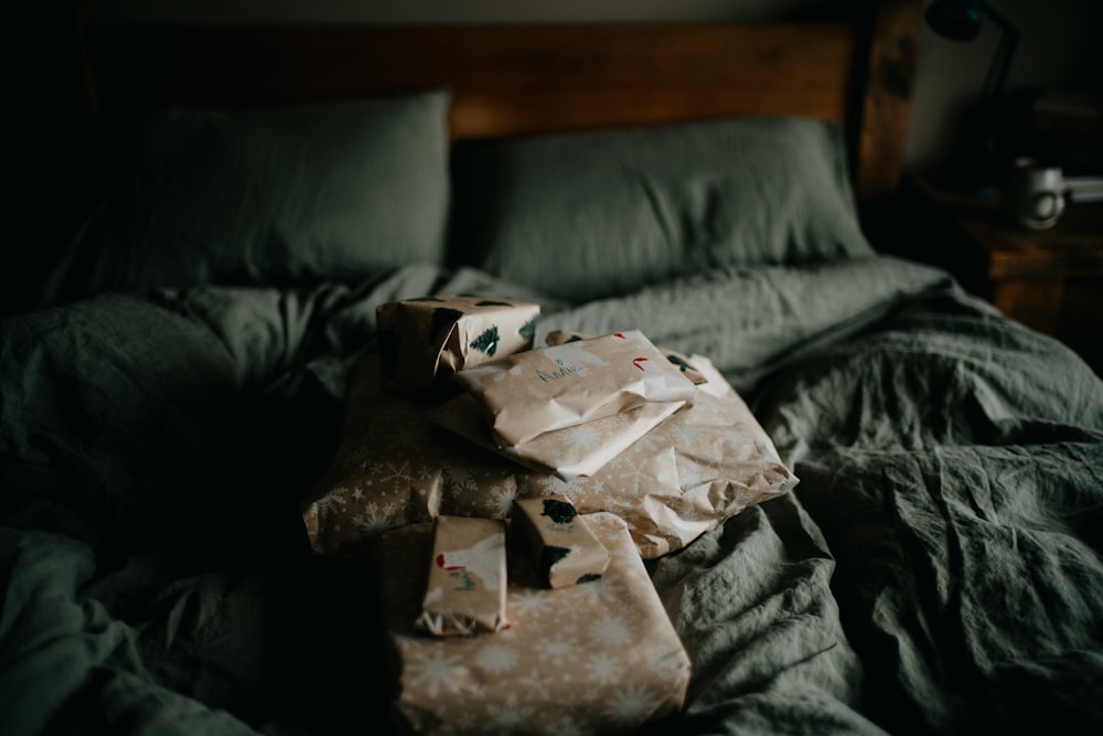 a pile of wrapped presents sitting on top of a bed