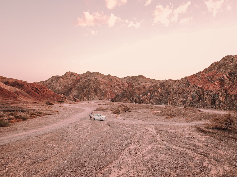 a car is parked in the middle of a desert