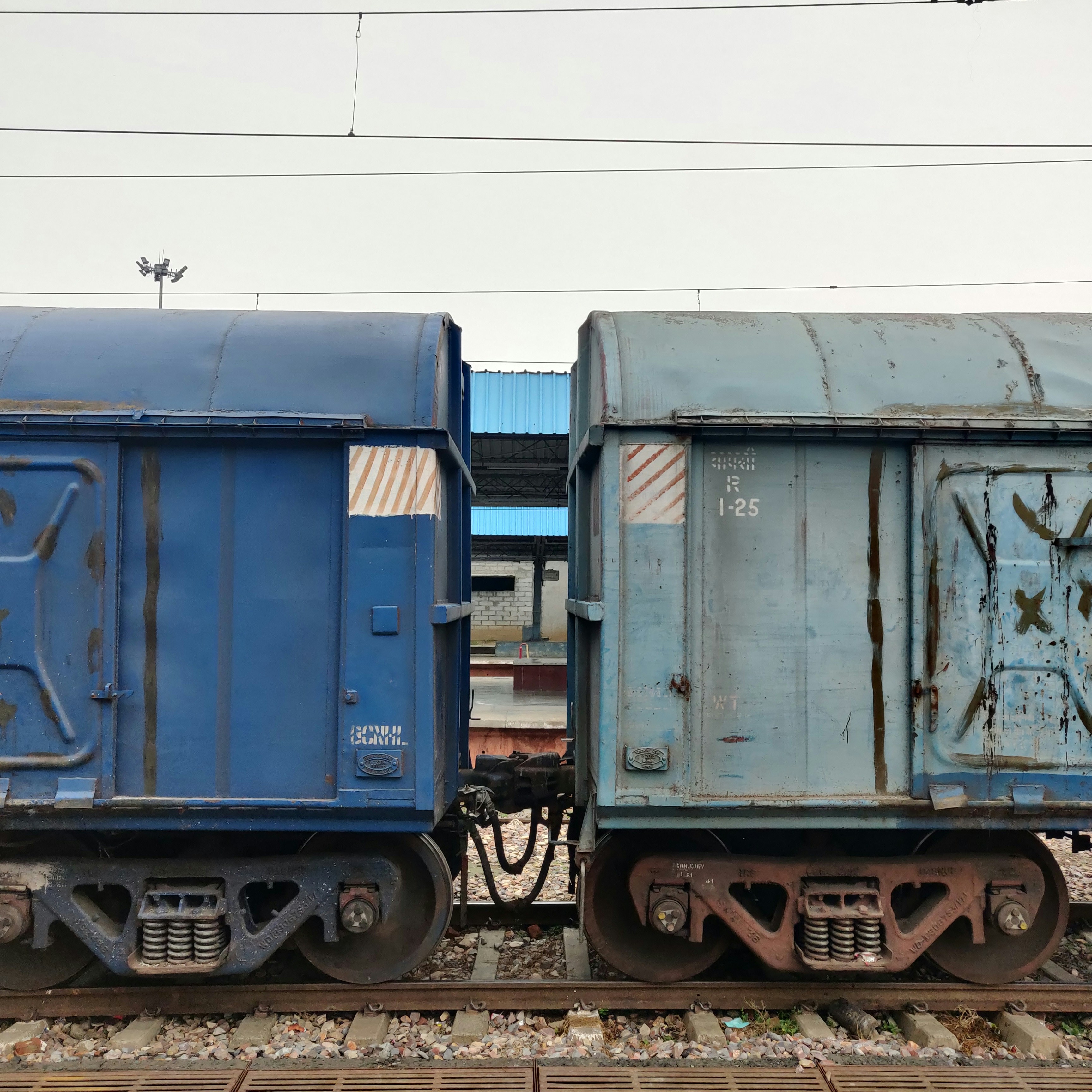 A couple of train cars sitting on top of train tracks photo – Free Blue ...