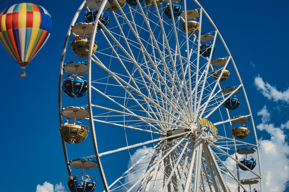 a ferris wheel and a hot air balloon in the sky