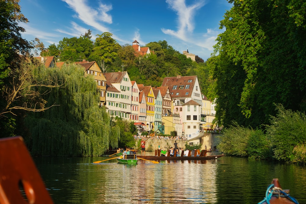 a row boat on a river with a row of houses in the background