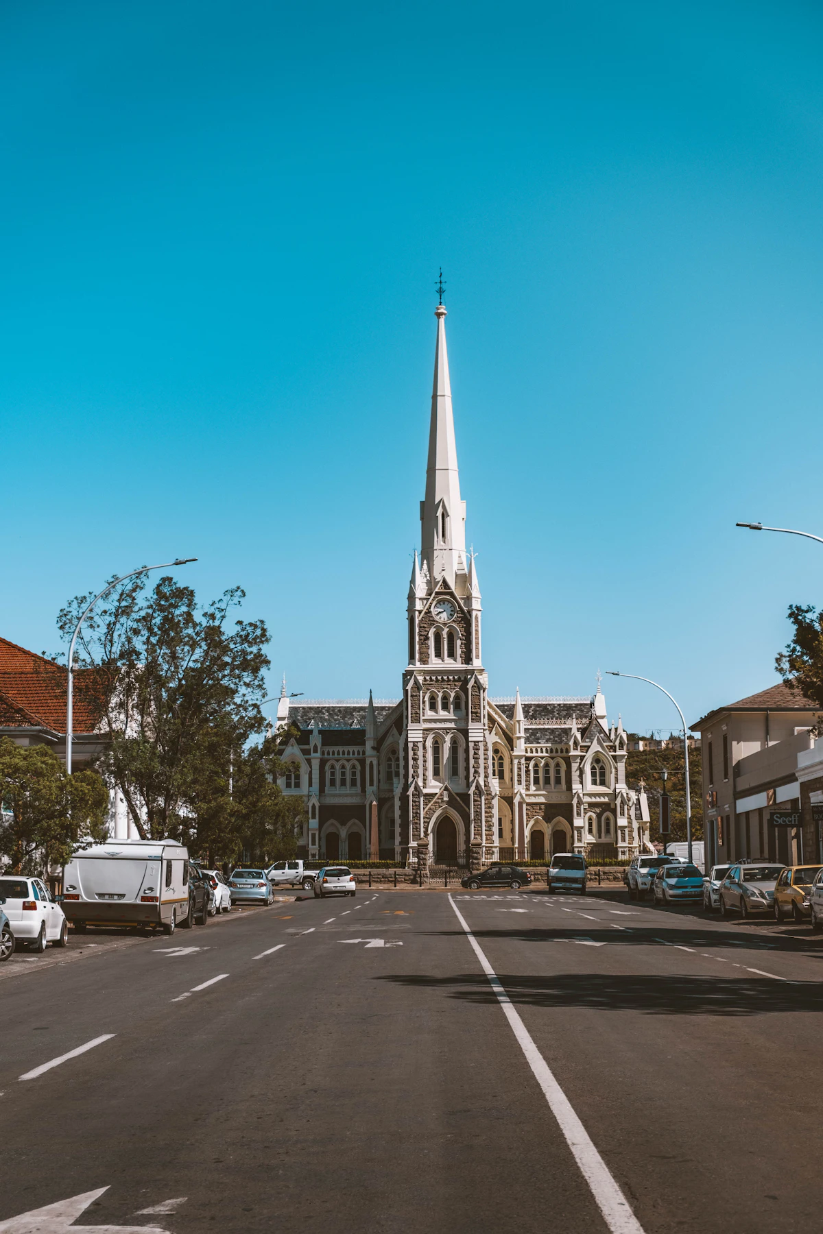 A church with a tall white spire at the end of a street in Graaff-Reinet