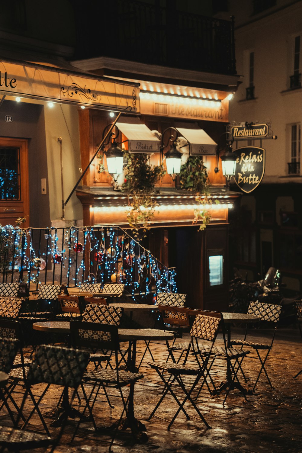 a table and chairs outside of a restaurant at night
