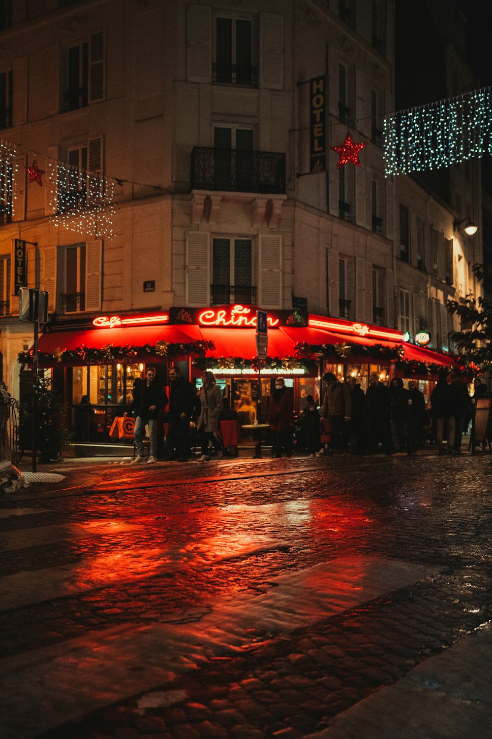 a group of people standing outside of a building at night