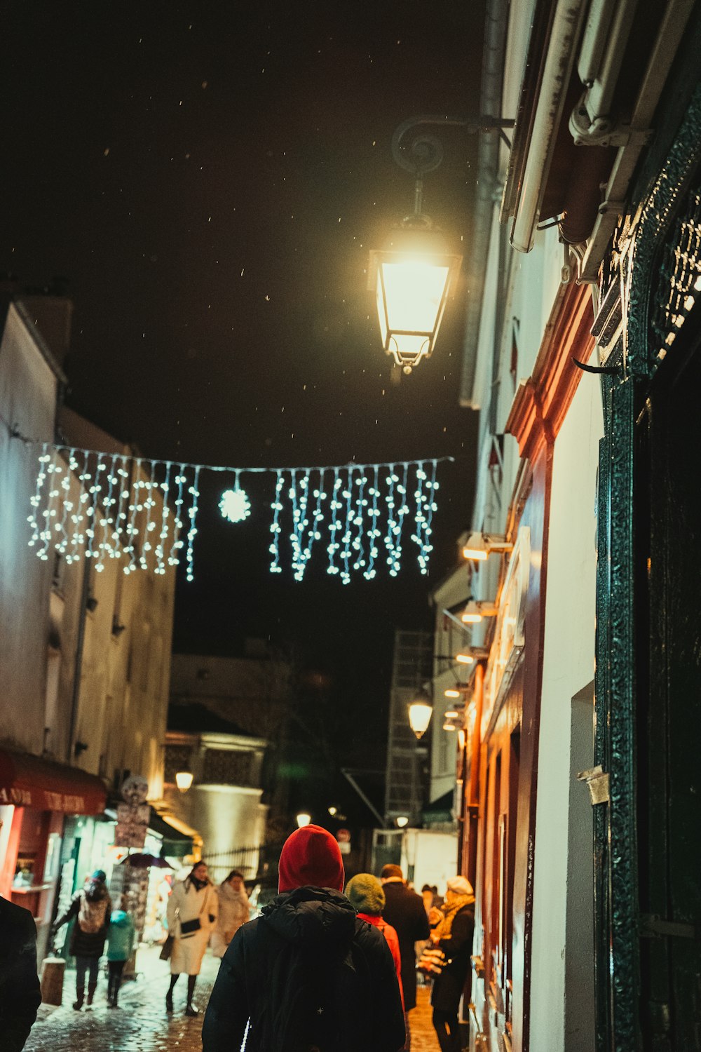 a group of people walking down a street at night