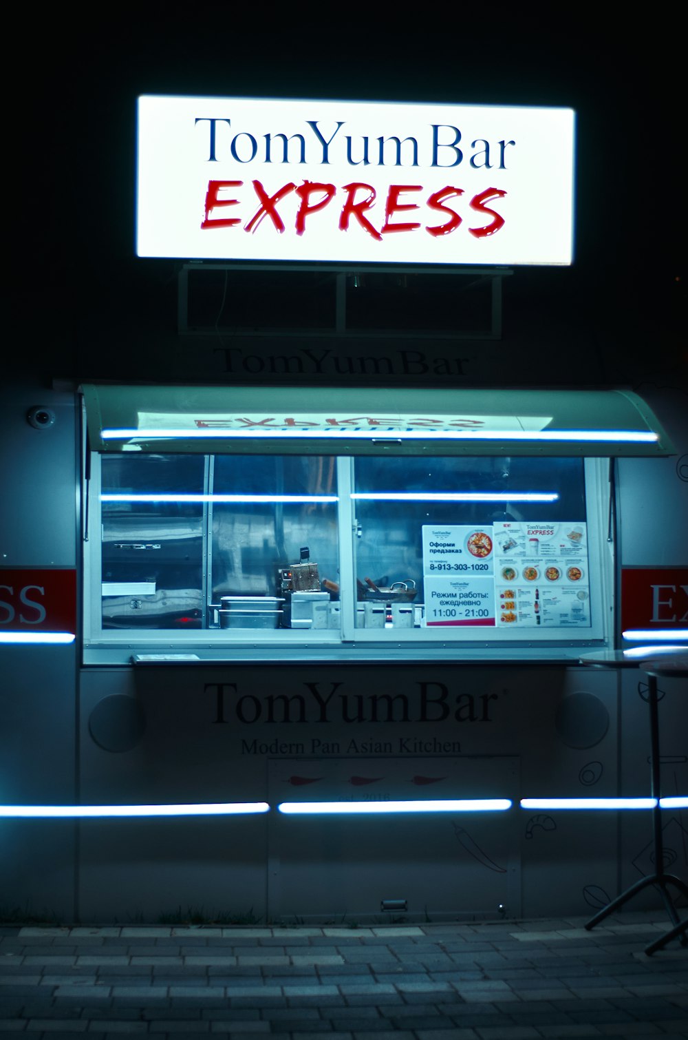 Un ristorante chiamato Tommy's Express illuminato di notte
