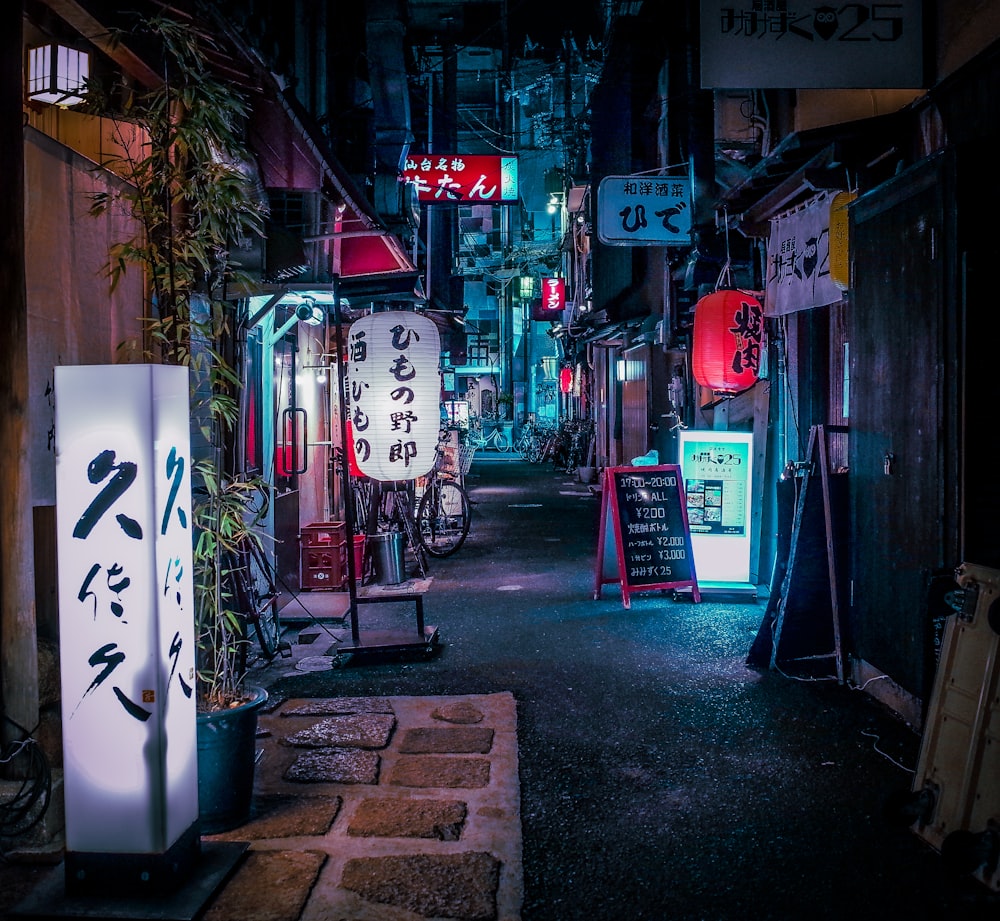 a narrow alley way with signs and lights