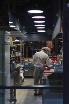 Chefs preparing fresh ingredients in a modern kitchen setting.