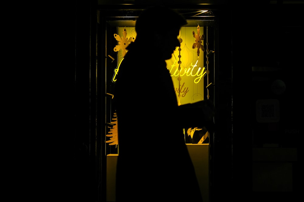 a silhouette of a man standing in a doorway