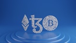 Symbols of Ethereum, Tezos, and Bitcoin are depicted using small white spheres on a blue, tiered platform, creating a modern and digital aesthetic.