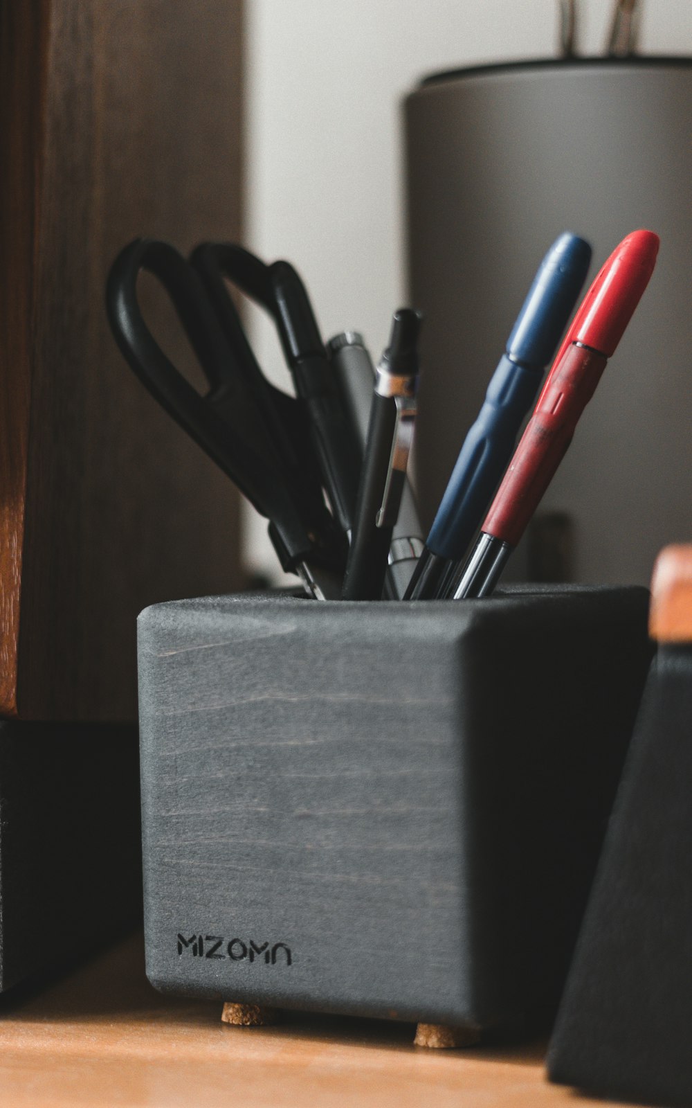 a pen holder with pens and scissors in it