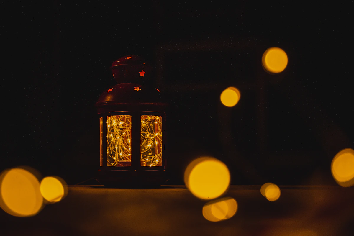 A lit lantern sitting on top of a table