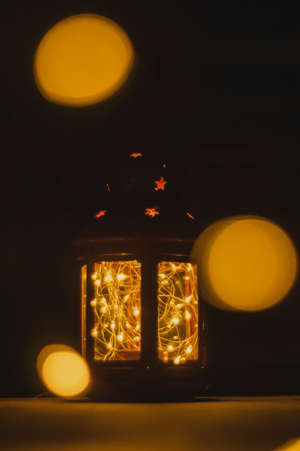 a lit up lantern sitting on top of a table