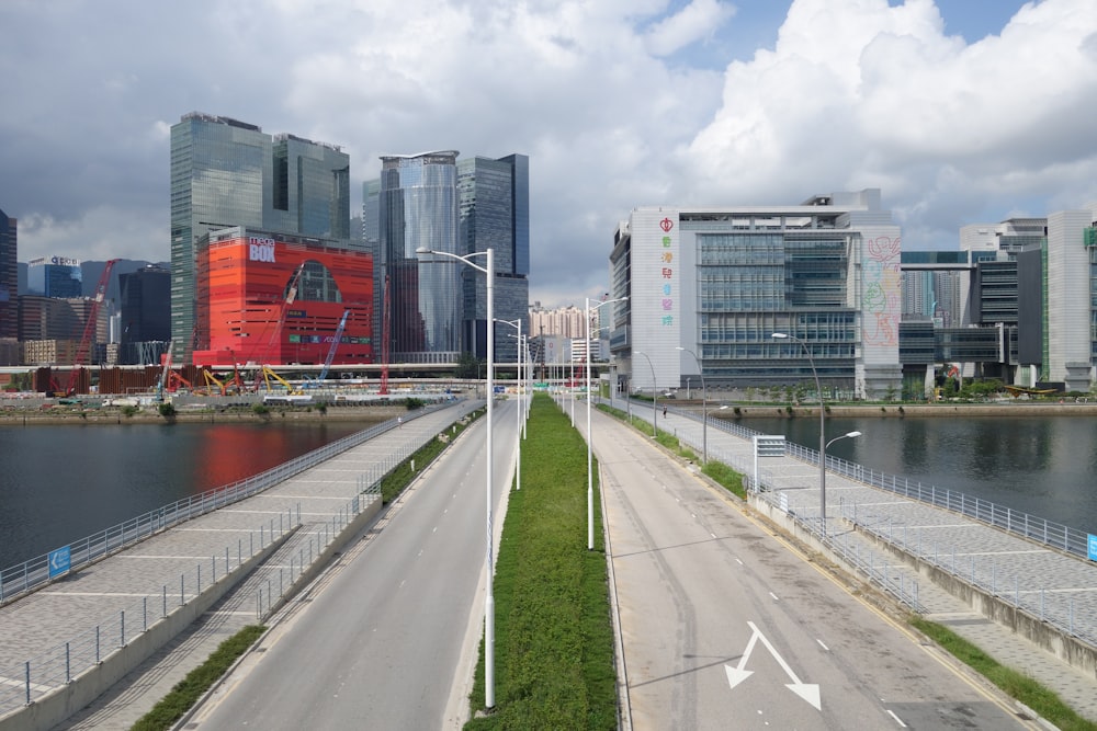 an empty road in a city with tall buildings in the background