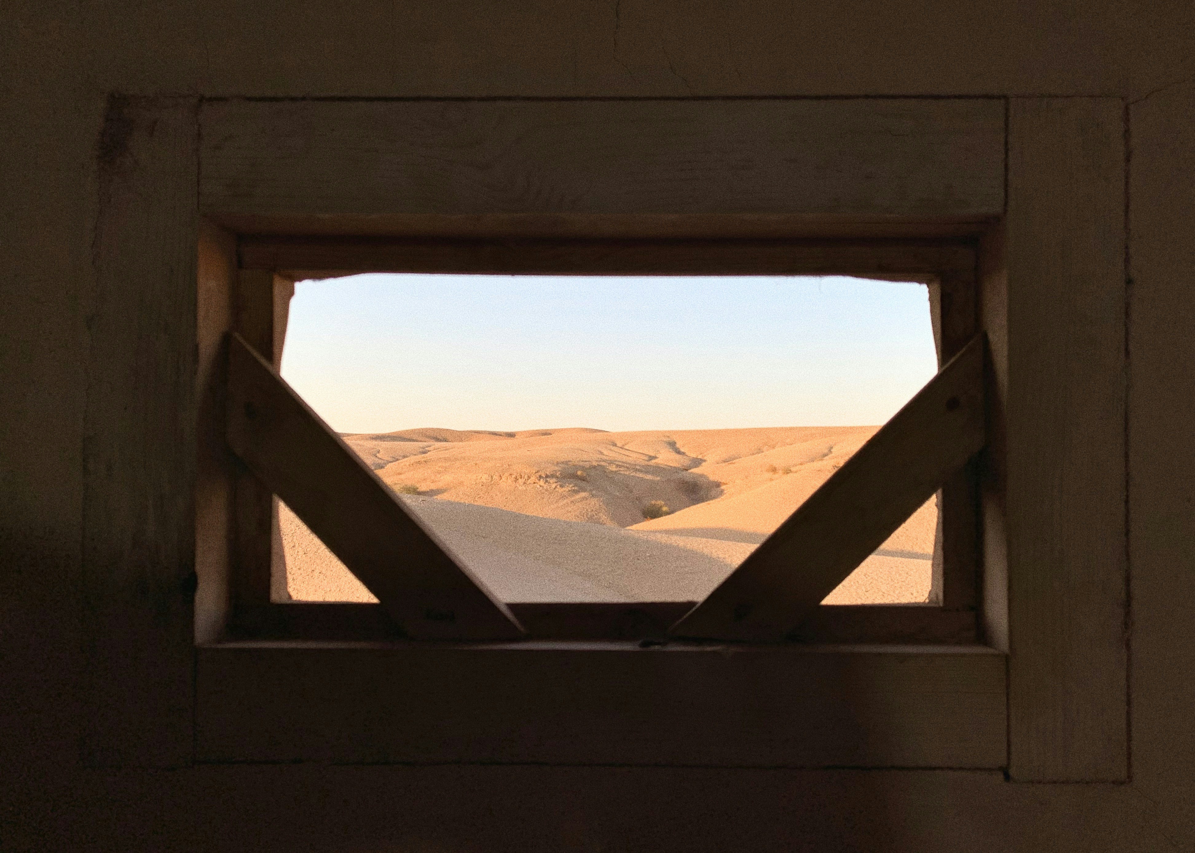 Stop image for Santa Fe to Monument Valley: 3-Day Desert Journey - a view of a desert through a window -  in Southwest USA - Photo by Kevin Lam on Unsplash