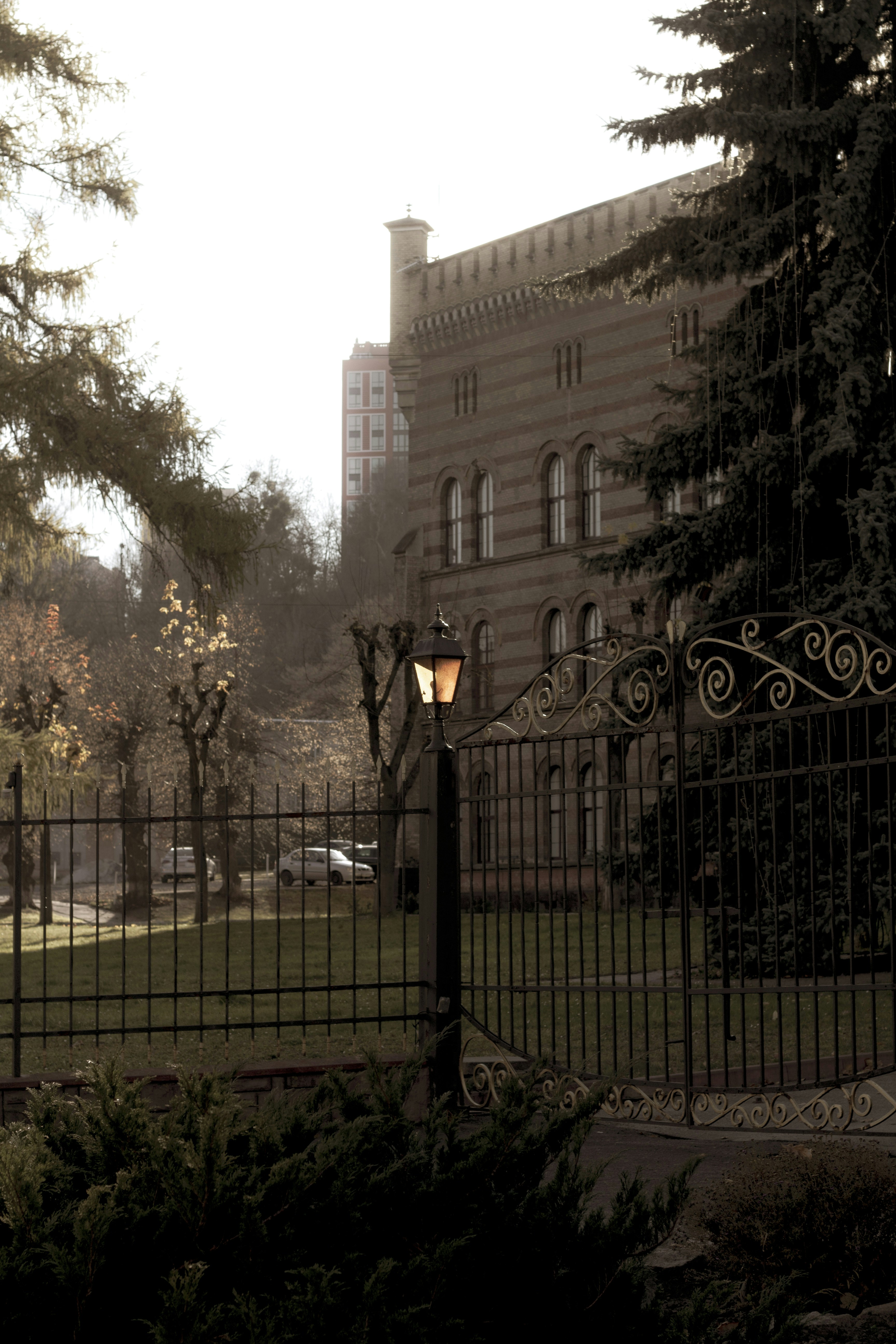 an iron gate with a light on it in front of a building